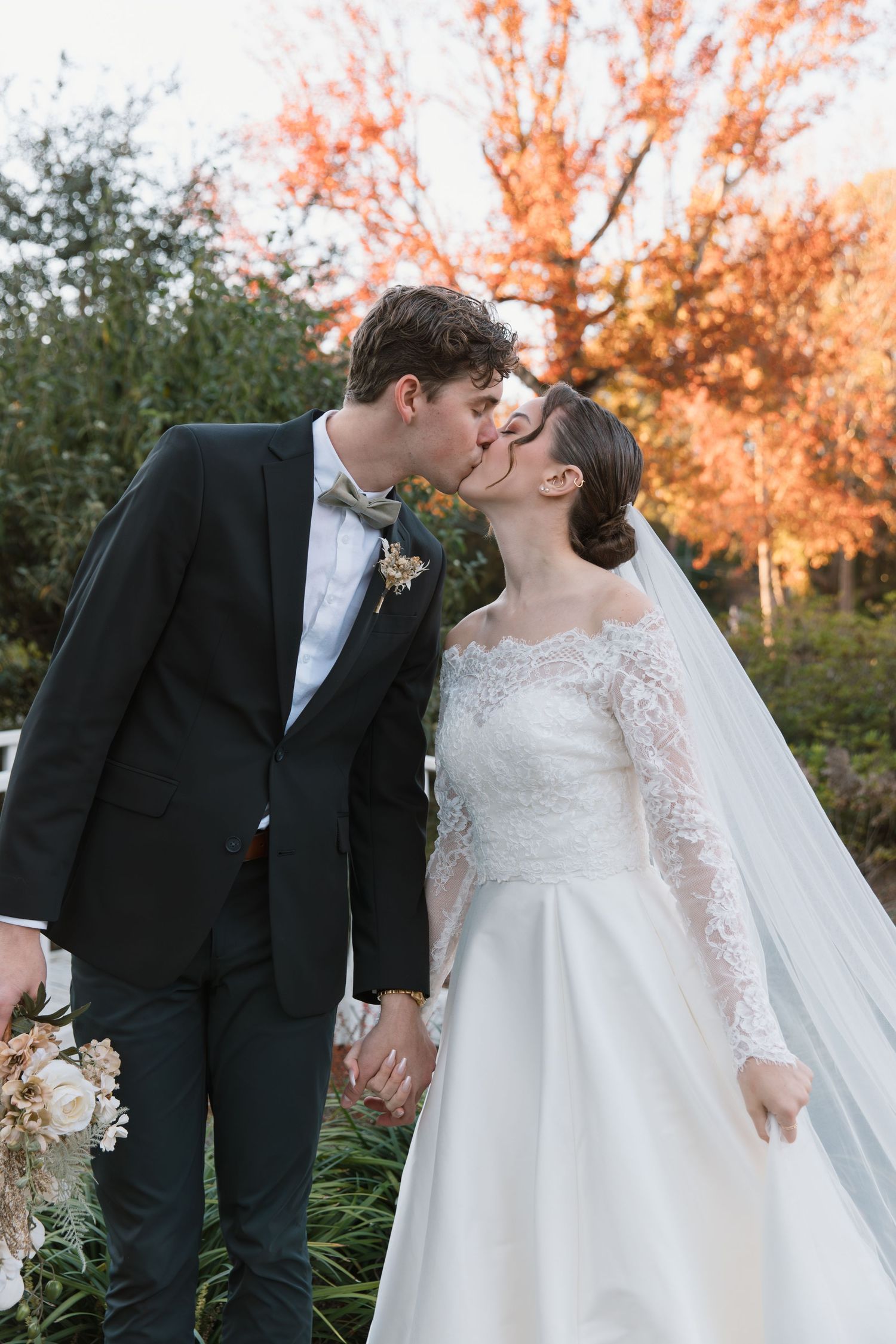 Romantic autumn wedding scene with fall foliage in the background.