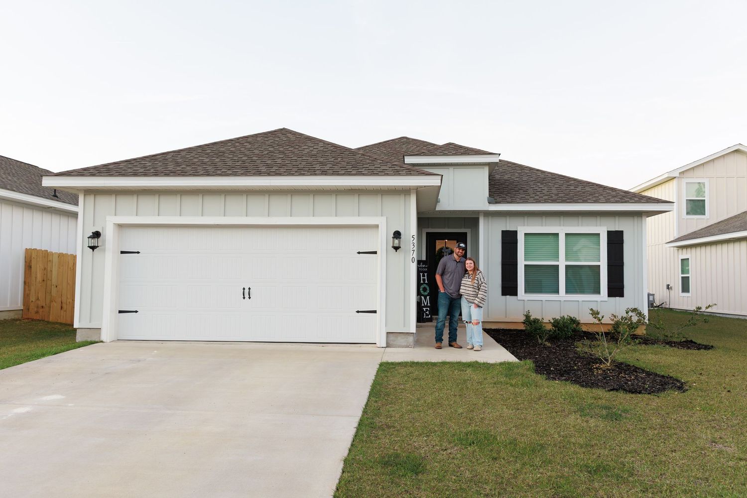 Exterior view of modern white garage doors on residential homes in a suburban neighborhood development.