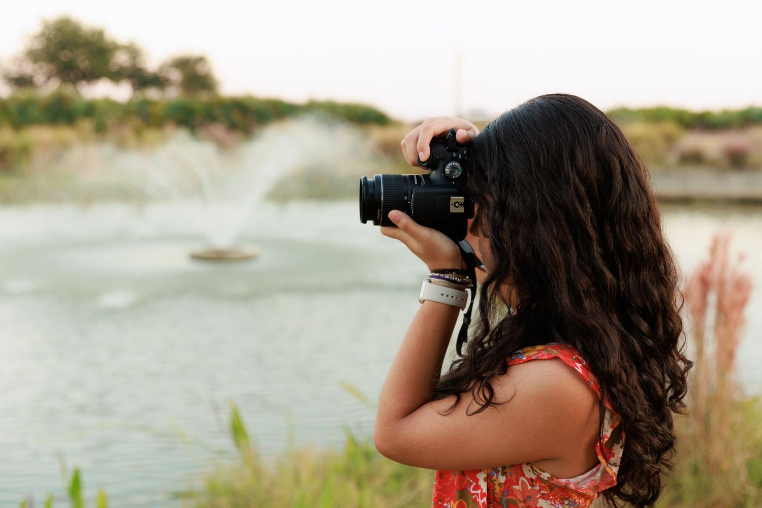 Photographer captures shots of pond fountain in evening light.