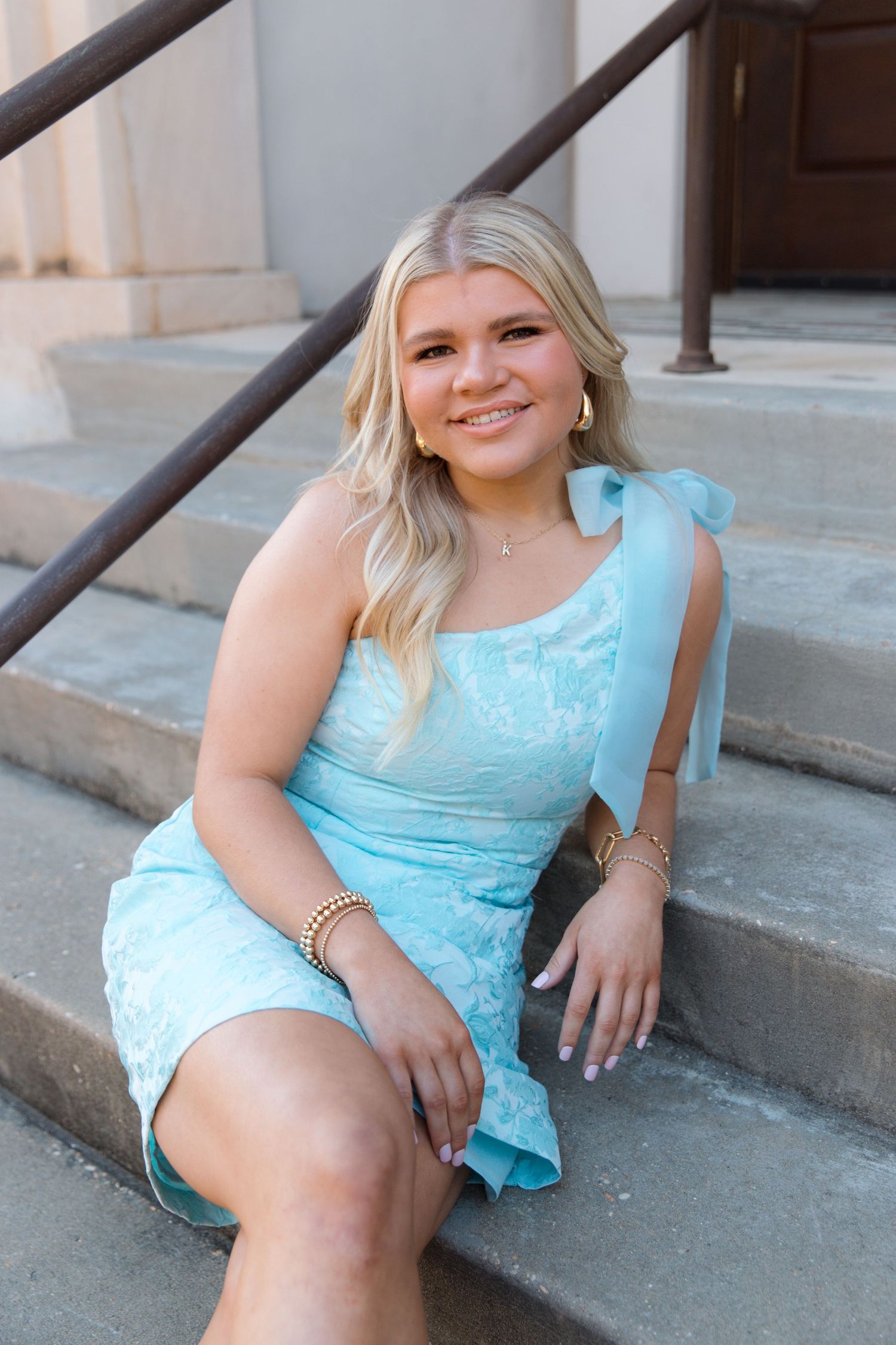 A young person in a light blue lace dress sits on stone steps in a series of casual outdoor portraits.