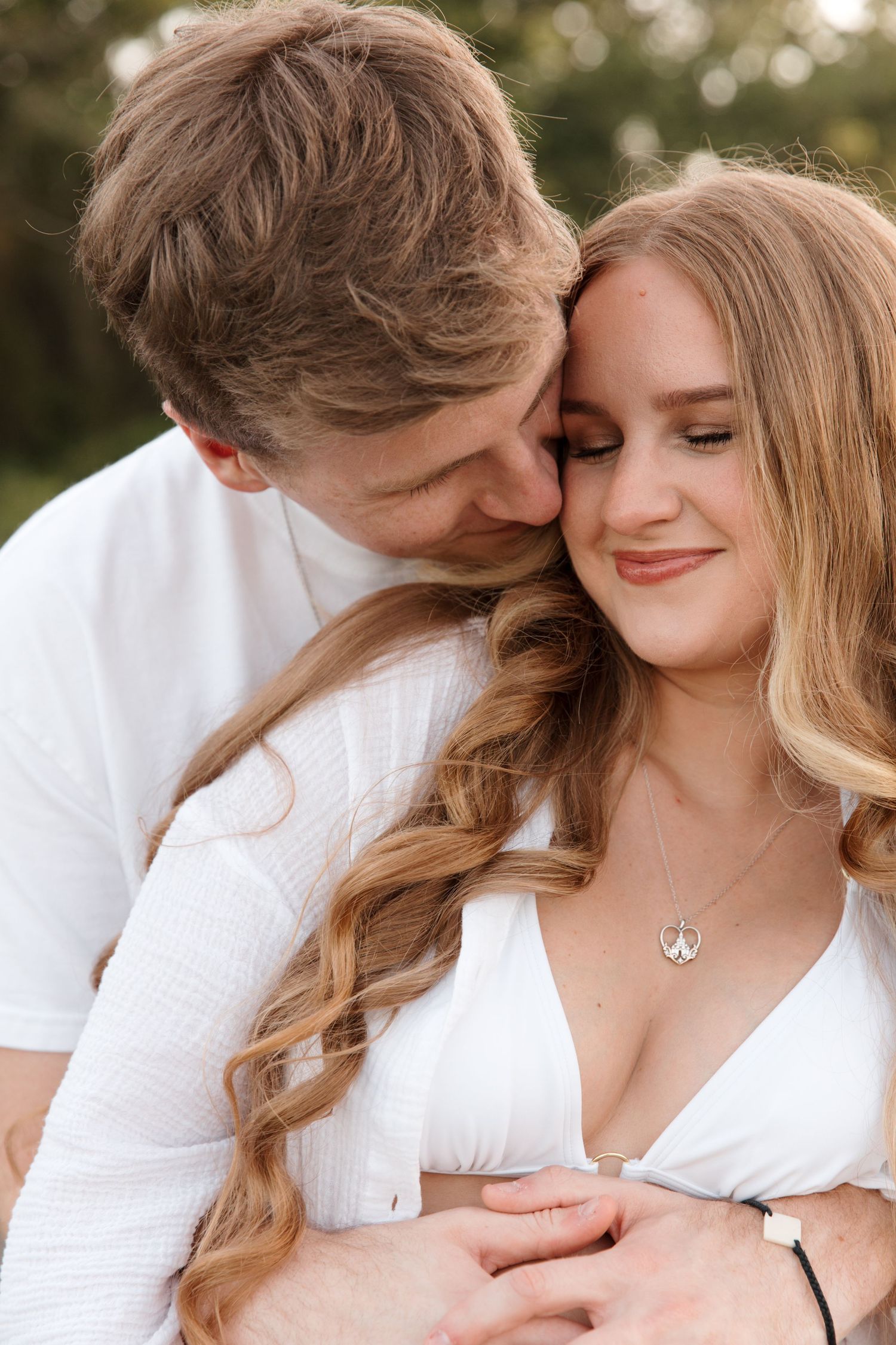A romantic couple in white outfits share intimate moments in a series of close-up photographs.