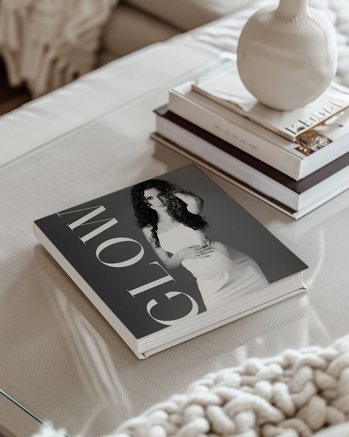 A series of minimalist black and white magazine covers arranged on a white surface with decorative objects.