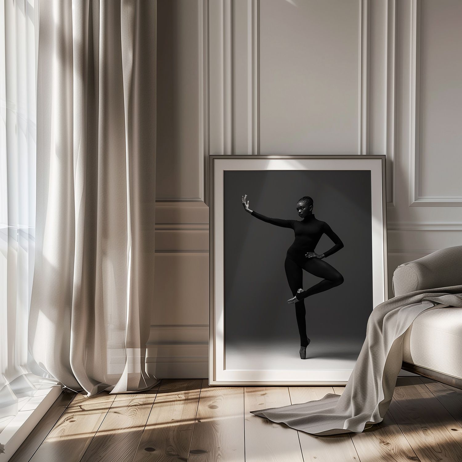 Elegant black and white dance photograph in a frame leaning against light gray paneled wall with flowing curtains.