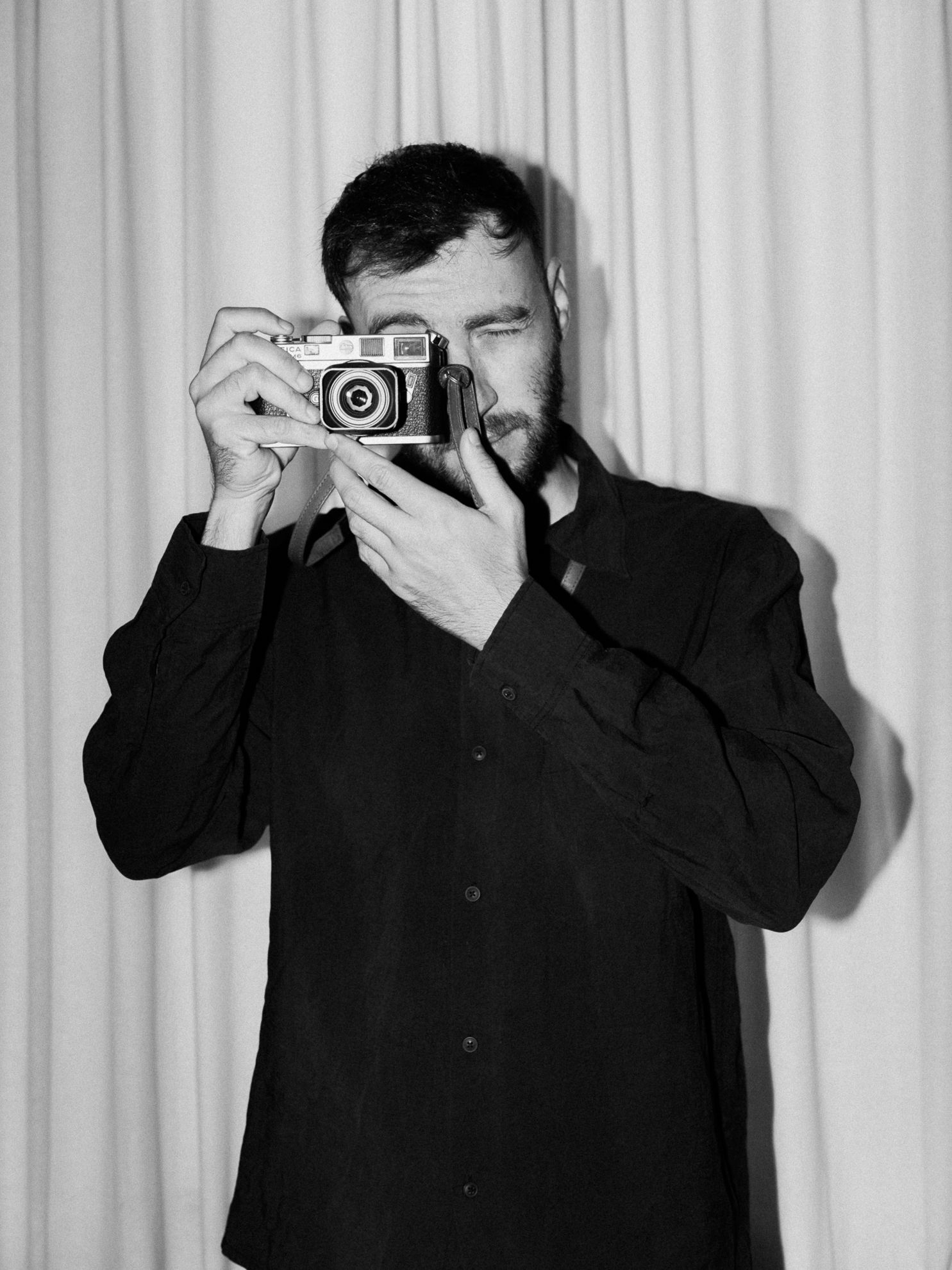 Photographer portrait (black and white) – A black-and-white portrait of a photographer holding a camera.