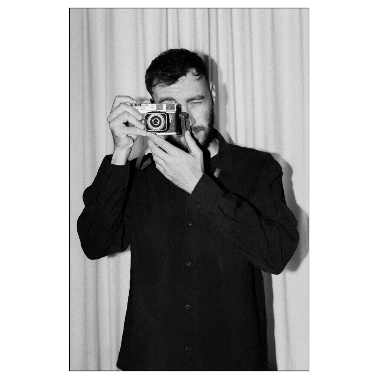 Photographer portrait (black and white) – A black-and-white portrait of a photographer holding a camera.