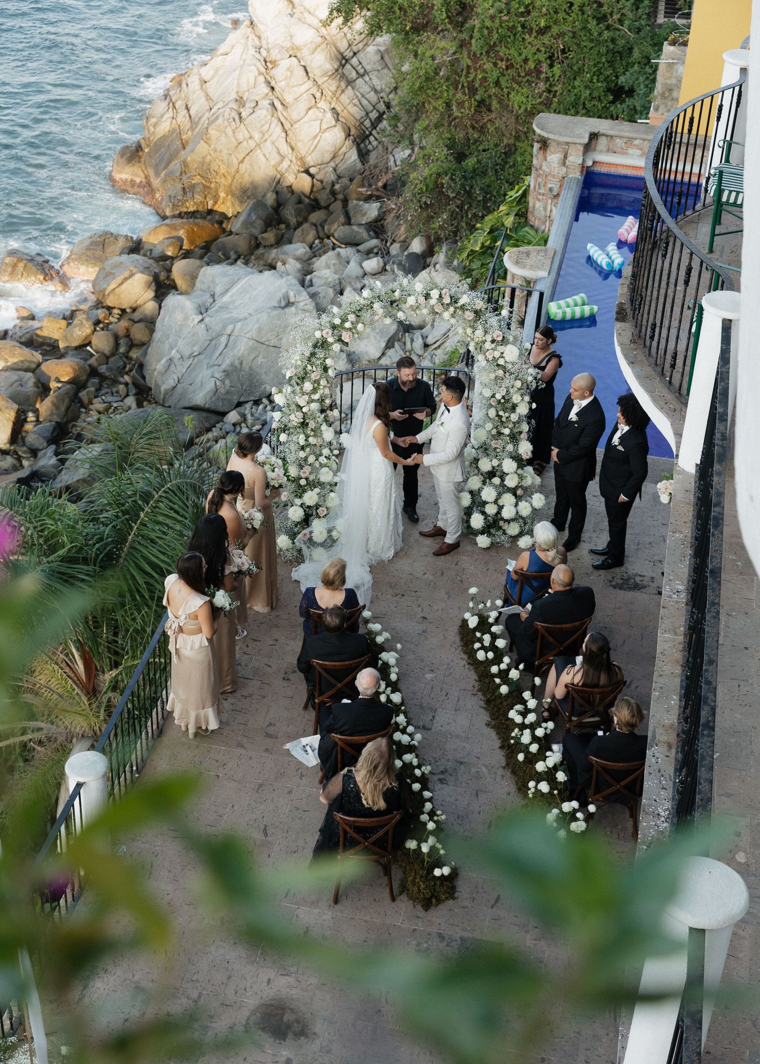An aerial photograph of a couple saying their vows at their coastal wedding venue in Puerto Vallarta, Mexico.