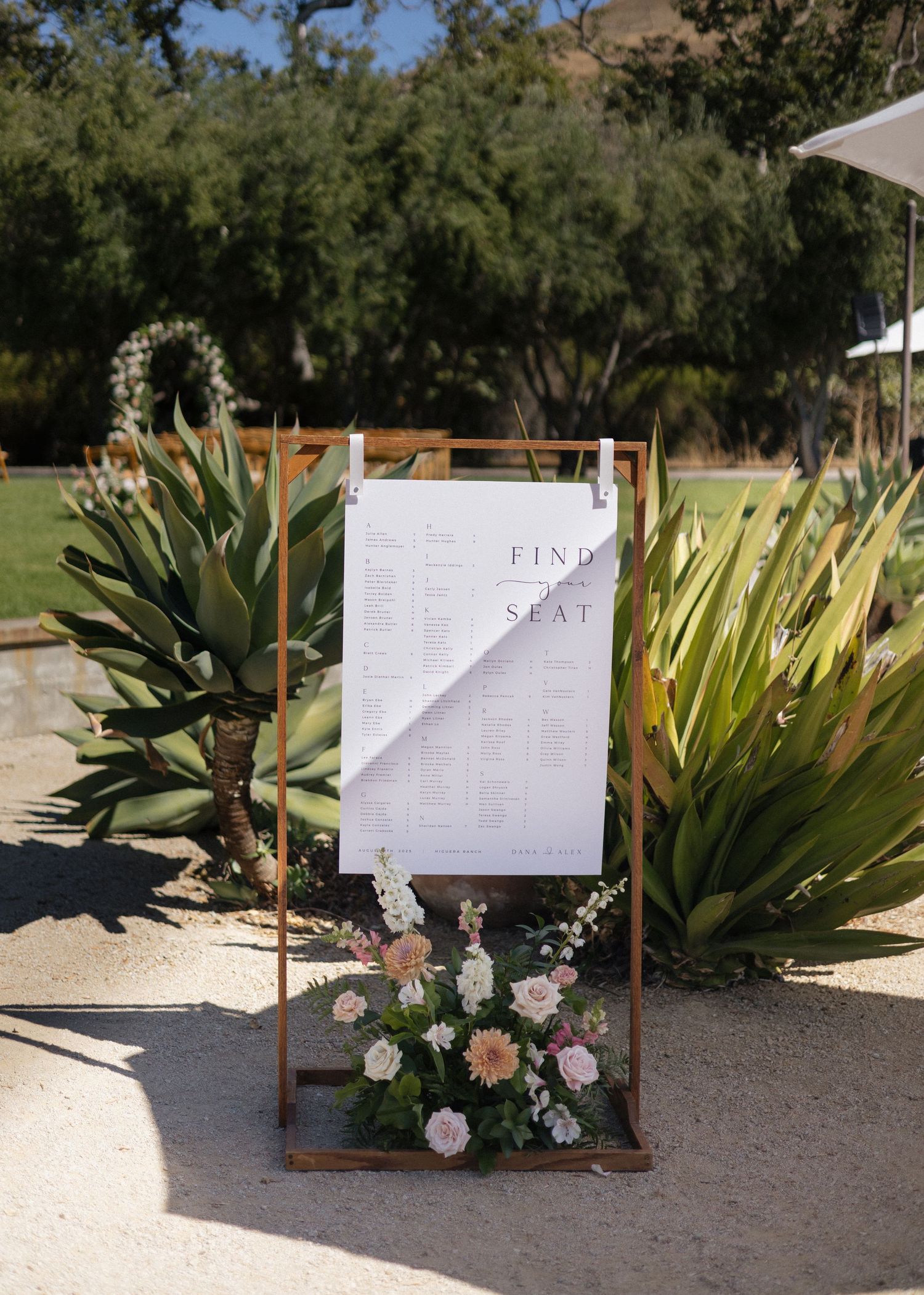 Wedding seating chart displays with copper frames and floral accents arranged against succulents at Higuera Ranch in San Luis Obispo, CA.