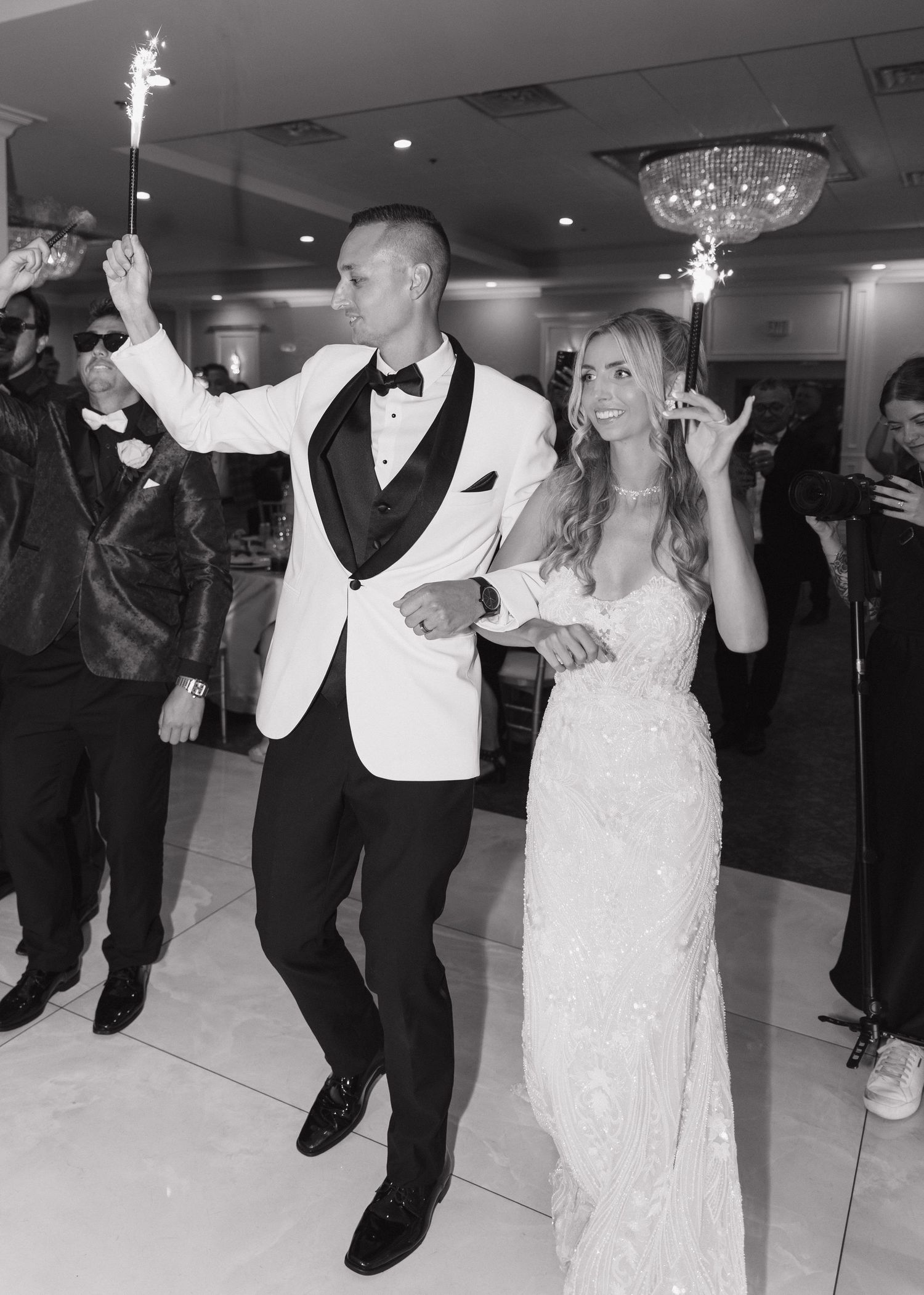 A bride and groom holding sparklers dancing at their wedding reception in an elegant ballroom in Chicago, Illinois.