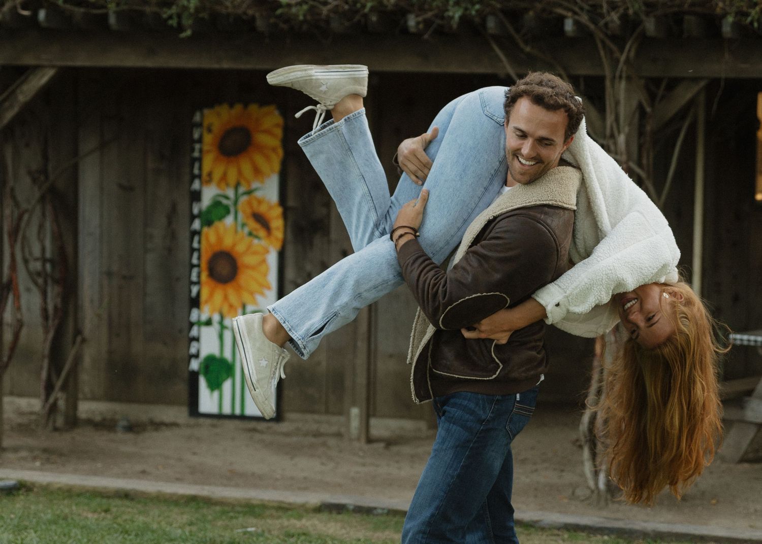 A couple running around with man carrying the girl on top of his back on a date night at Avila Valley Barn in California.