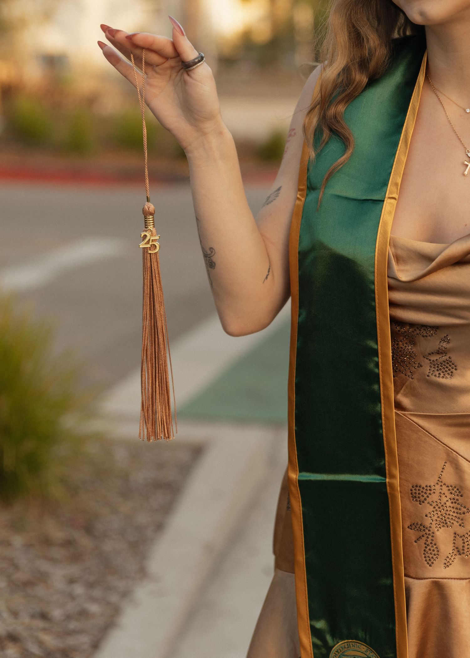 A detail photo of a Cal Poly San Luis Obispo graduate holding her tassle.