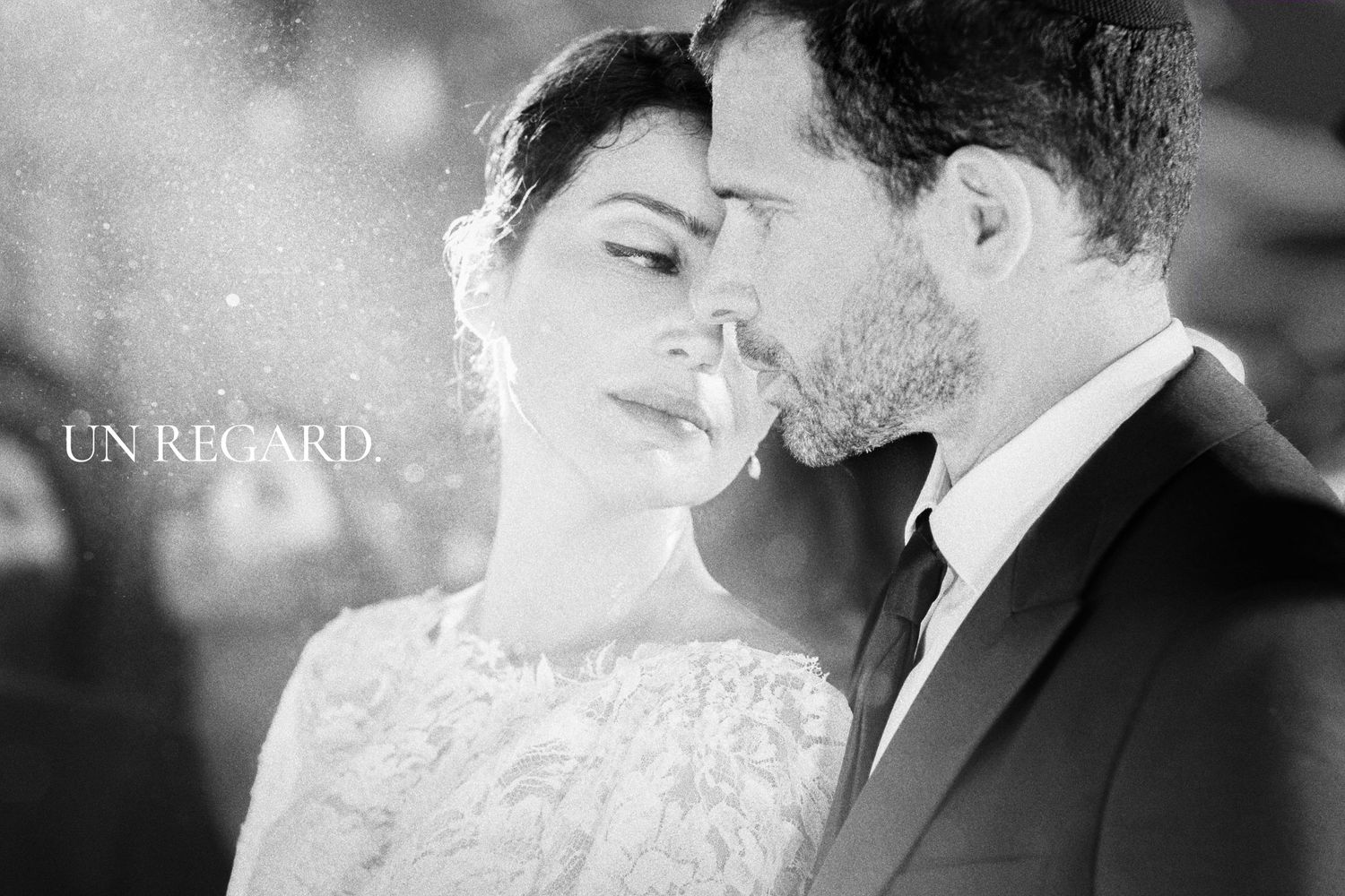 A romantic black and white close-up wedding photo with soft lighting effects.