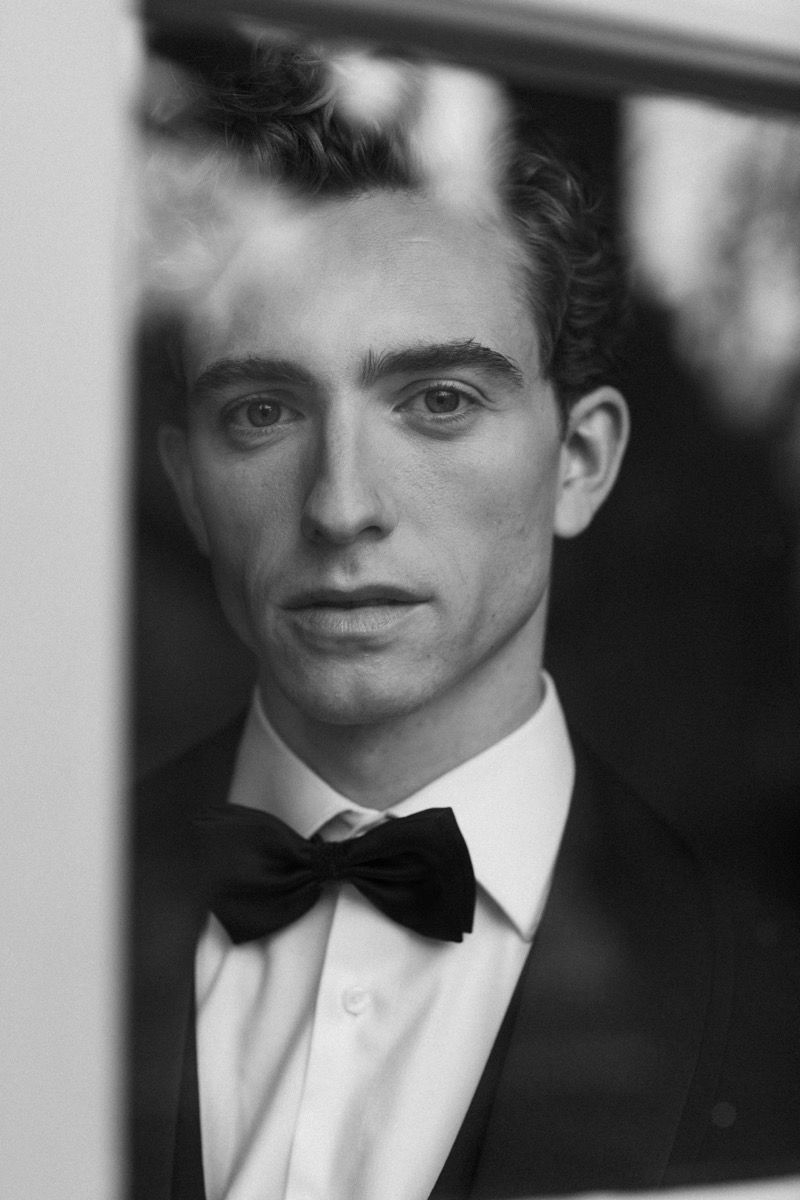 Classic black and white portrait of person in tuxedo and bowtie.