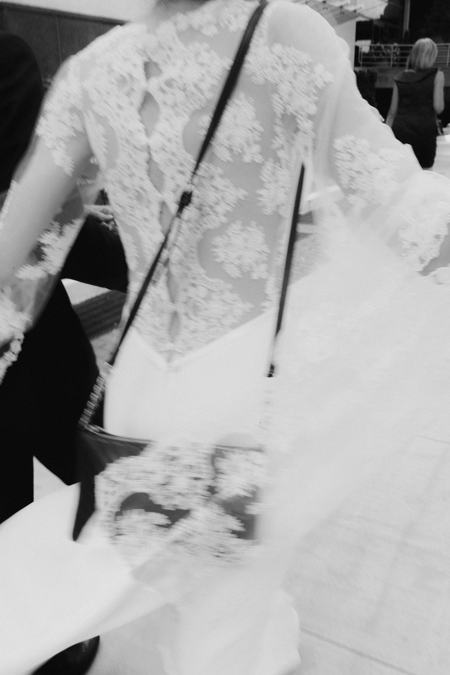 Close-up detail of lace wedding dress back with buttons and intricate patterns.