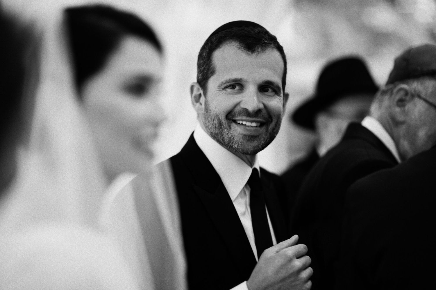 A black and white candid moment captures joy during a wedding ceremony.