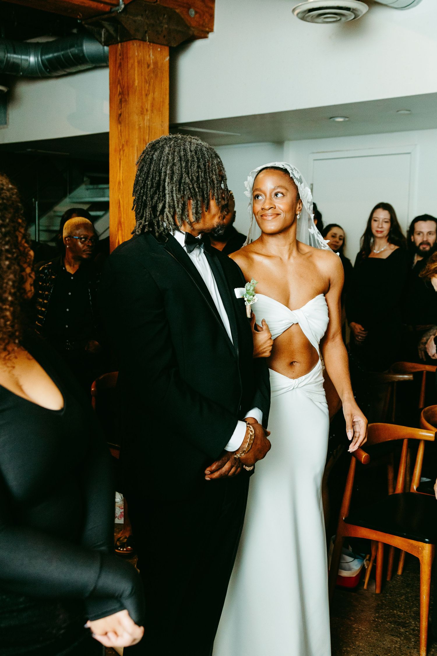A couple shares an intimate moment on their wedding day, with the bride wearing a stunning cutout white gown.