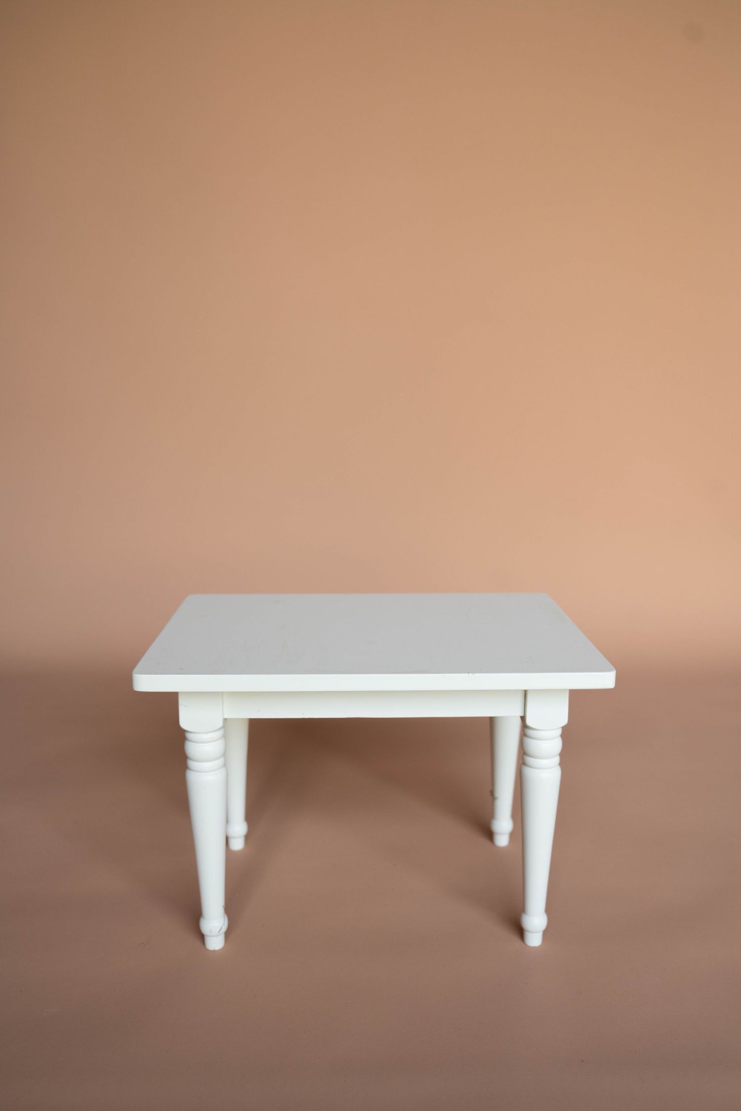 White farmhouse style table with turned legs shown from different perspectives.