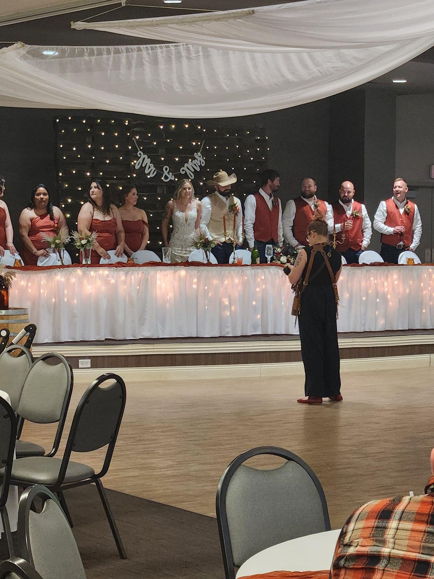 Large event venue with white tablecloths and chairs set up for a formal gathering.