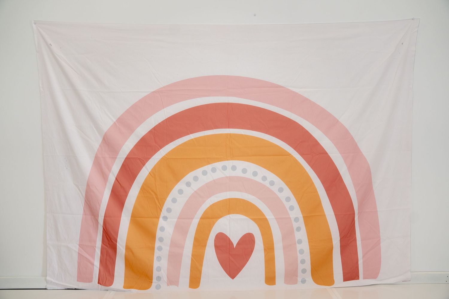 Minimalist rainbow backdrop in soft pastel colors with heart design.