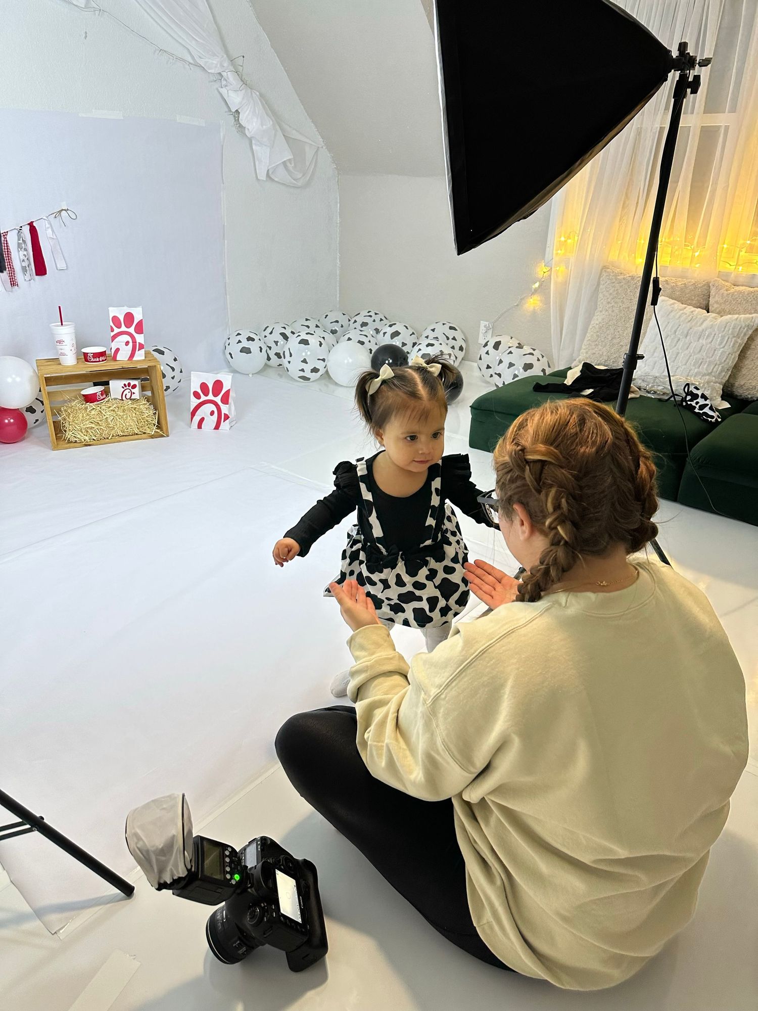 Studio photoshoot setup with children sitting on white floor.
