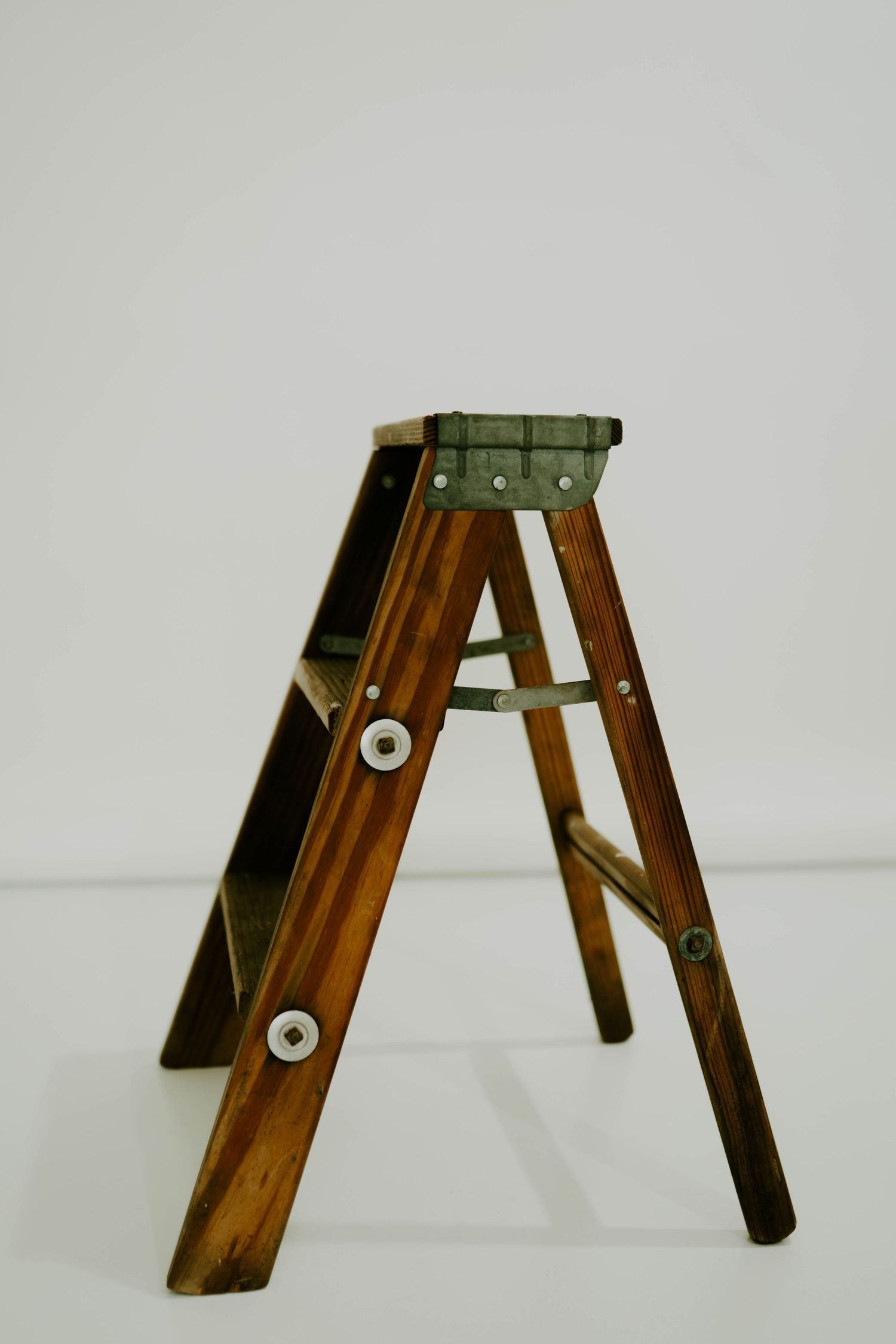 Wooden step ladder photographed against white background.