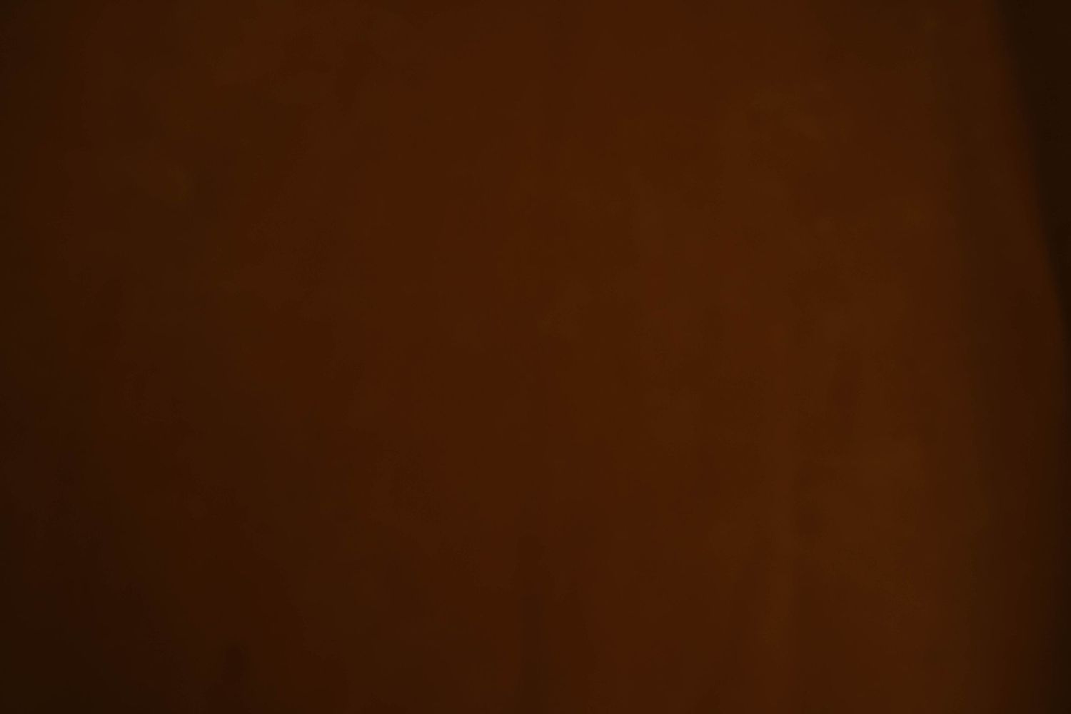 Dark brown gradient background with vignette edges.