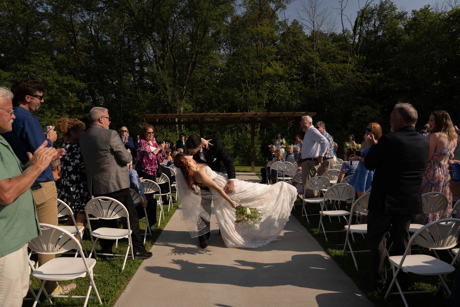 Outdoor wedding reception with guests mingling on a sunny patio.