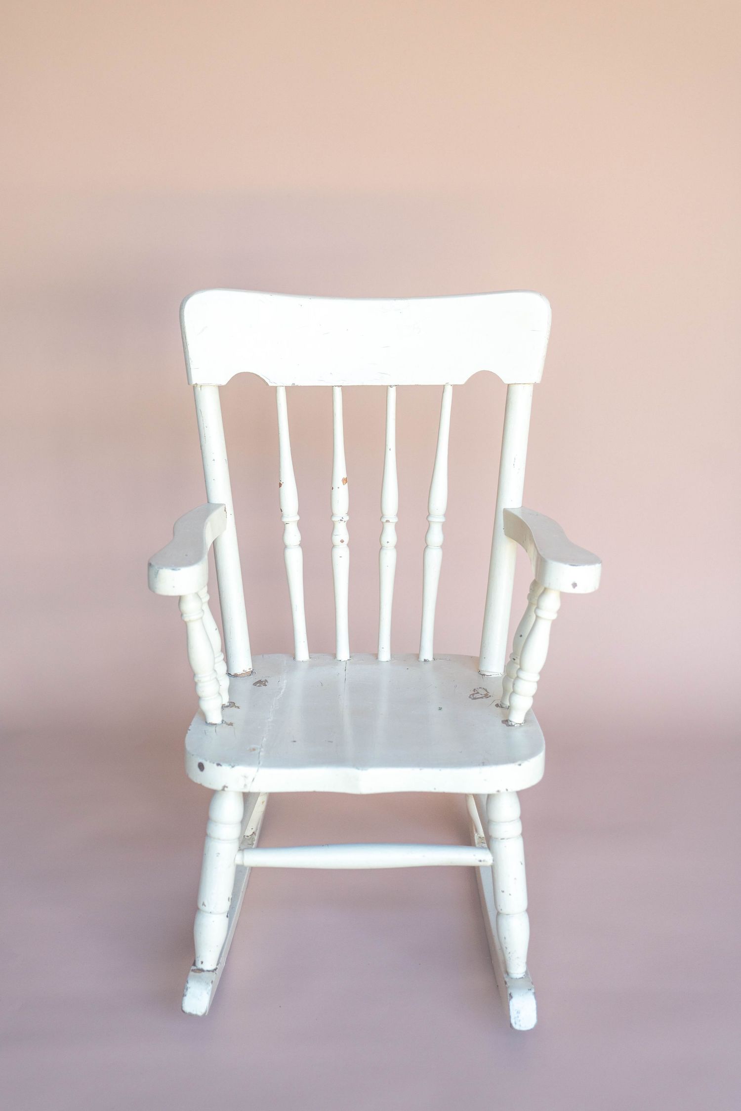 White wooden rocking chair shown from different angles against a neutral background.