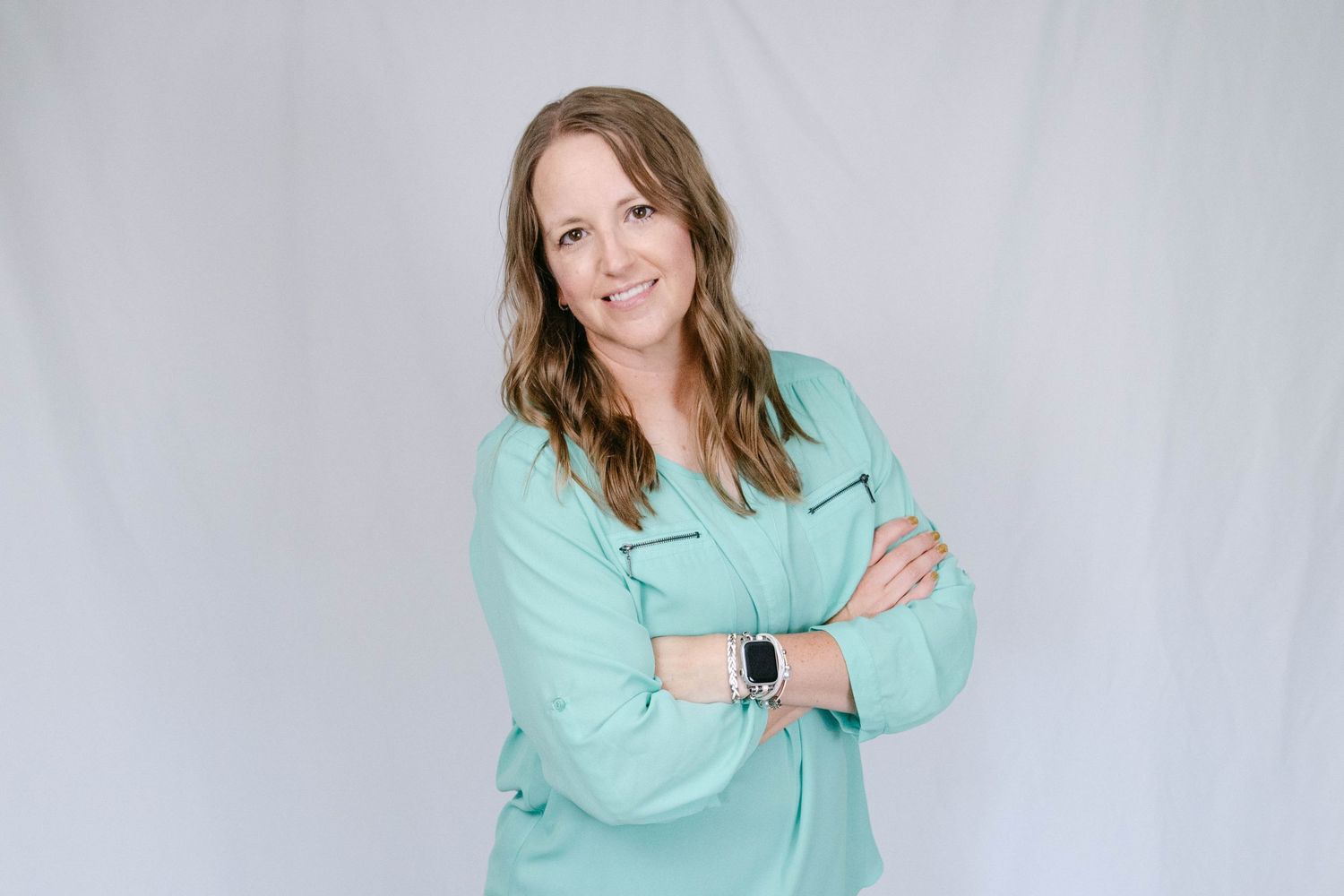 Professional headshots of someone wearing a mint green blazer posing against a light gray background.