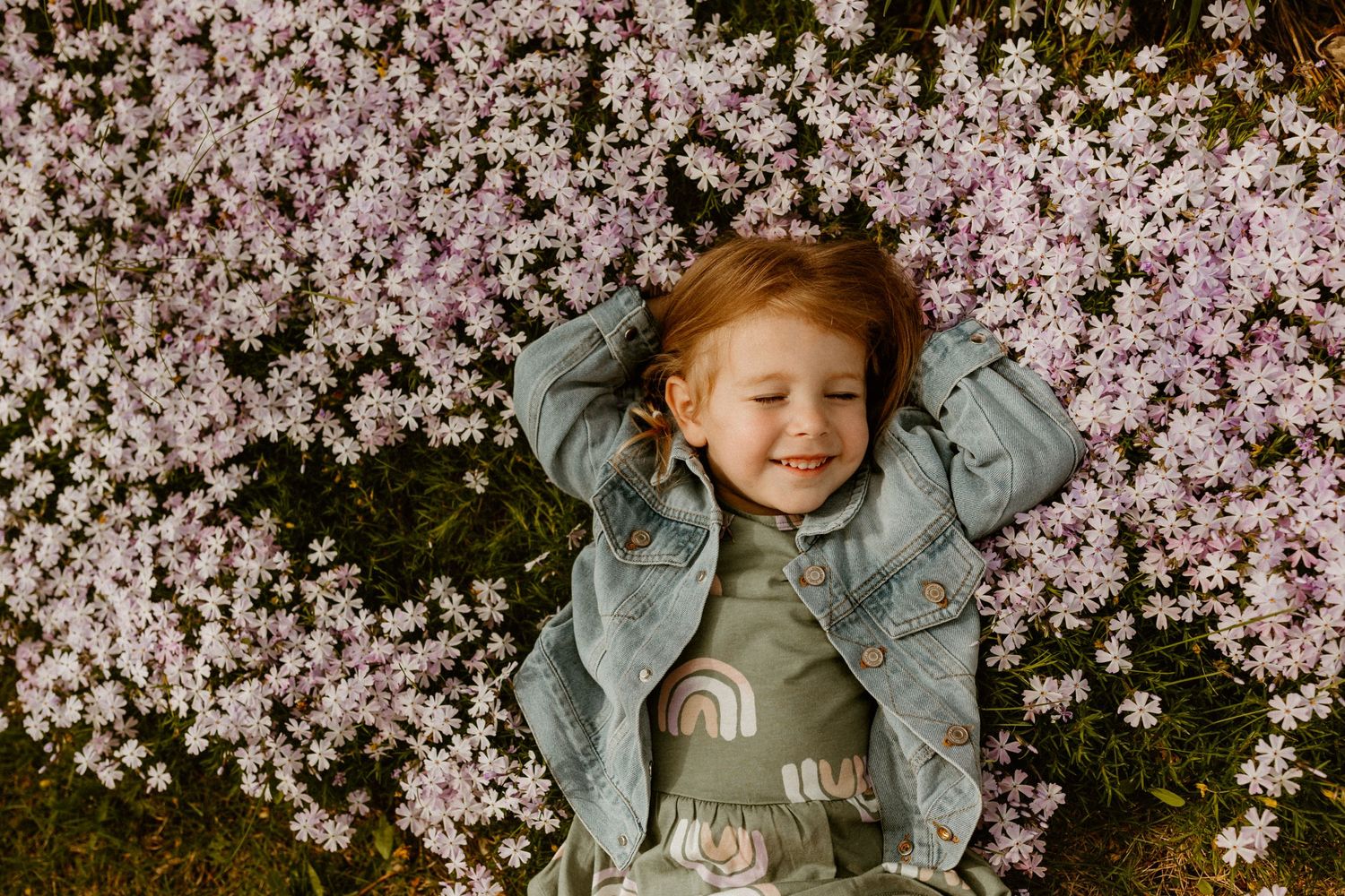A delightful springtime scene with cherry blossoms framing a cheerful expression in soft natural light.