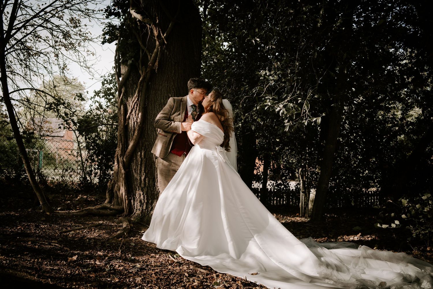 A romantic forest wedding scene with a white gown flowing in the breeze among tall trees and natural lighting.