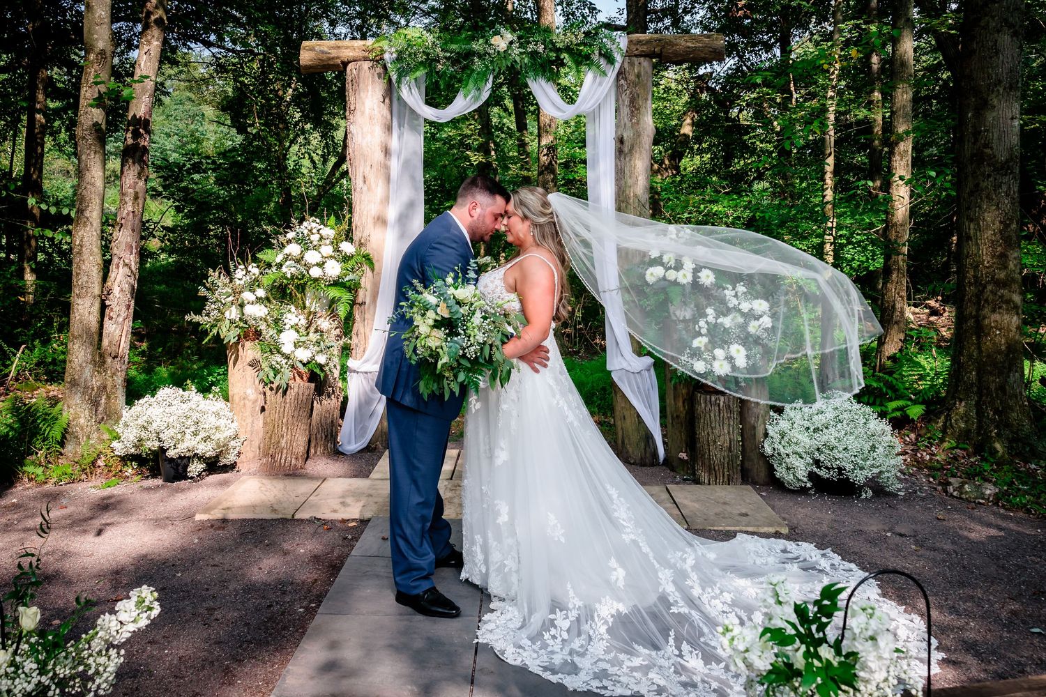 Wedding couple photographs in lush green forest setting.