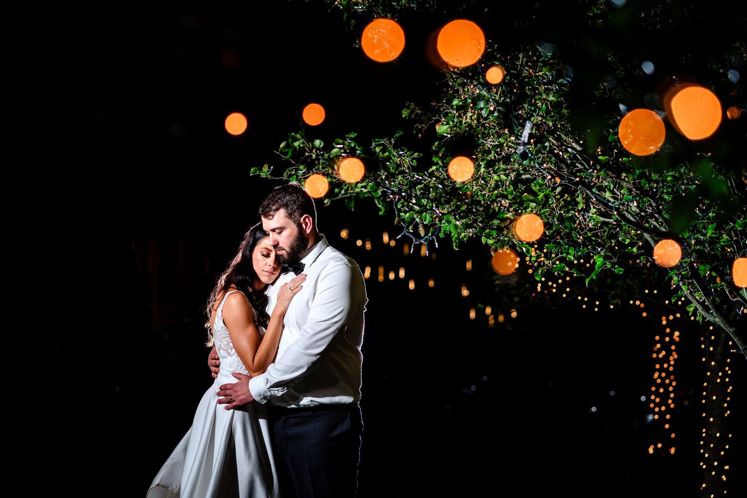 Romantic evening wedding photos with glowing orange lanterns overhead.