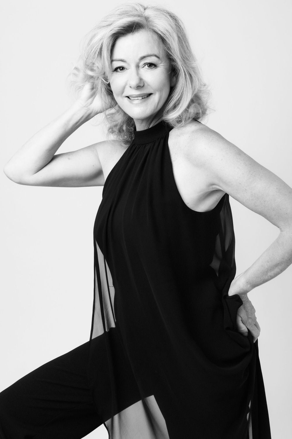 Artistic black and white portrait series featuring flowing black dress against white backdrop.