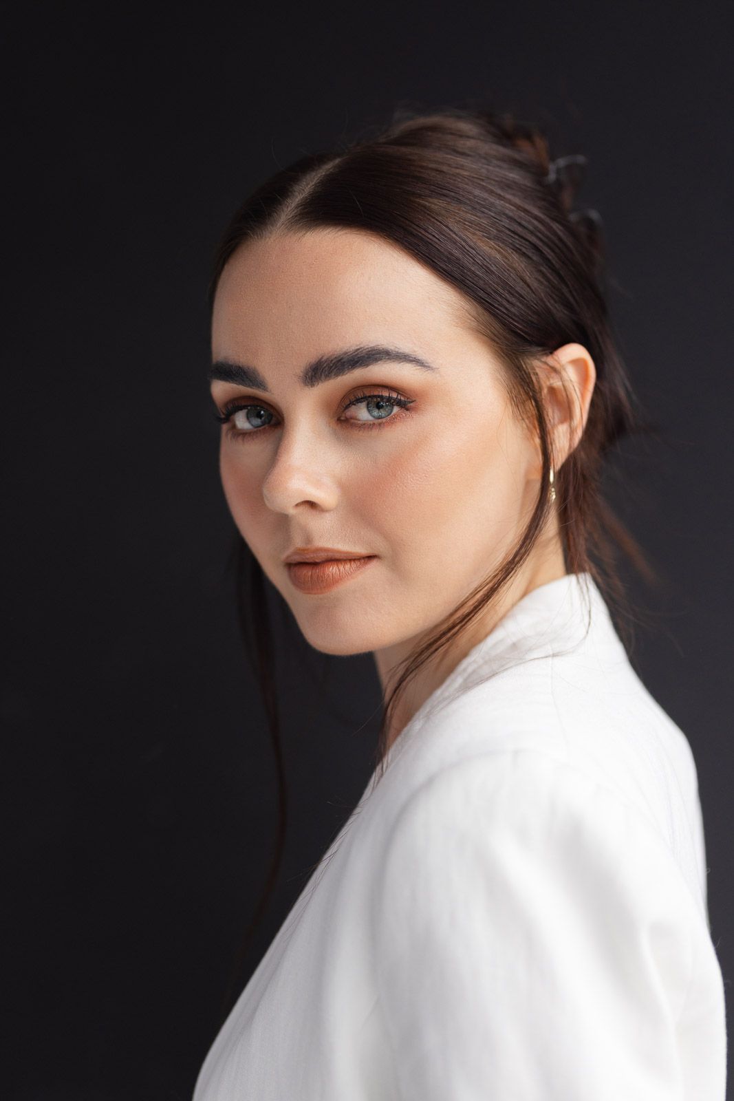 Portrait series against dark background showing elegant white blazer styling.