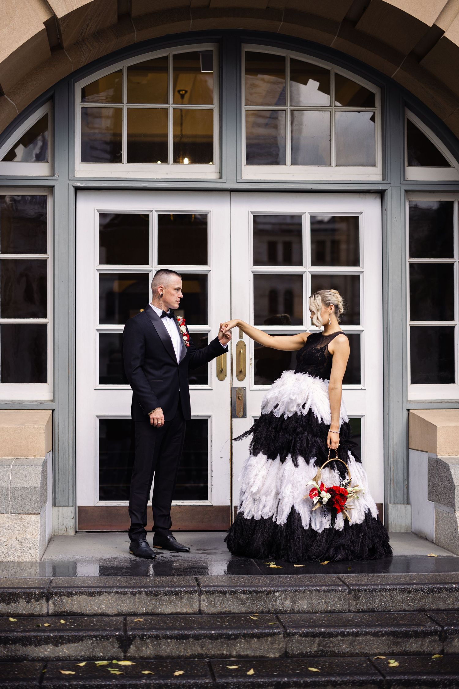 Wedding photo series with black and white attire against classic architectural backdrop.