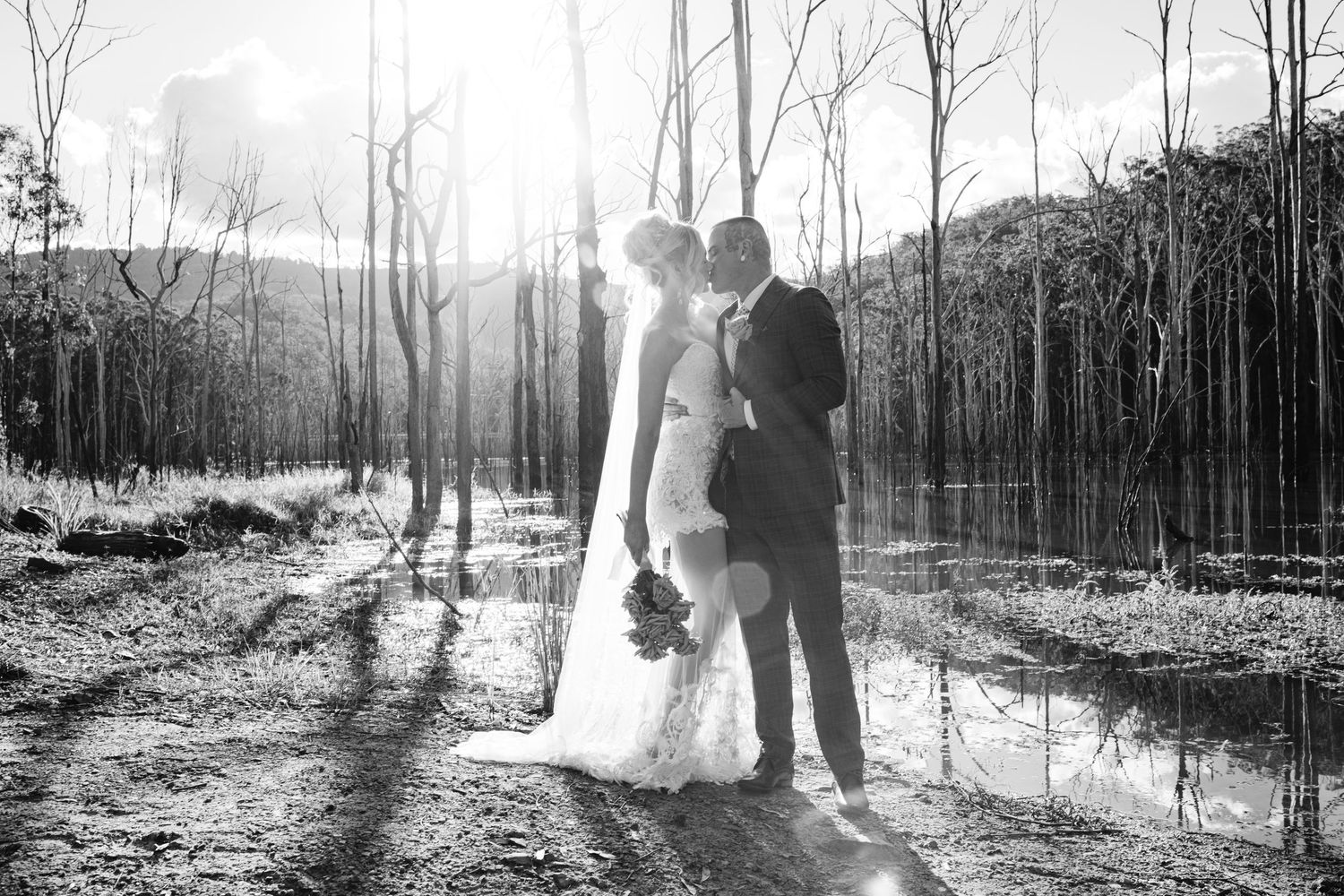 Black and white winter wedding photos showing silhouettes among bare trees.
