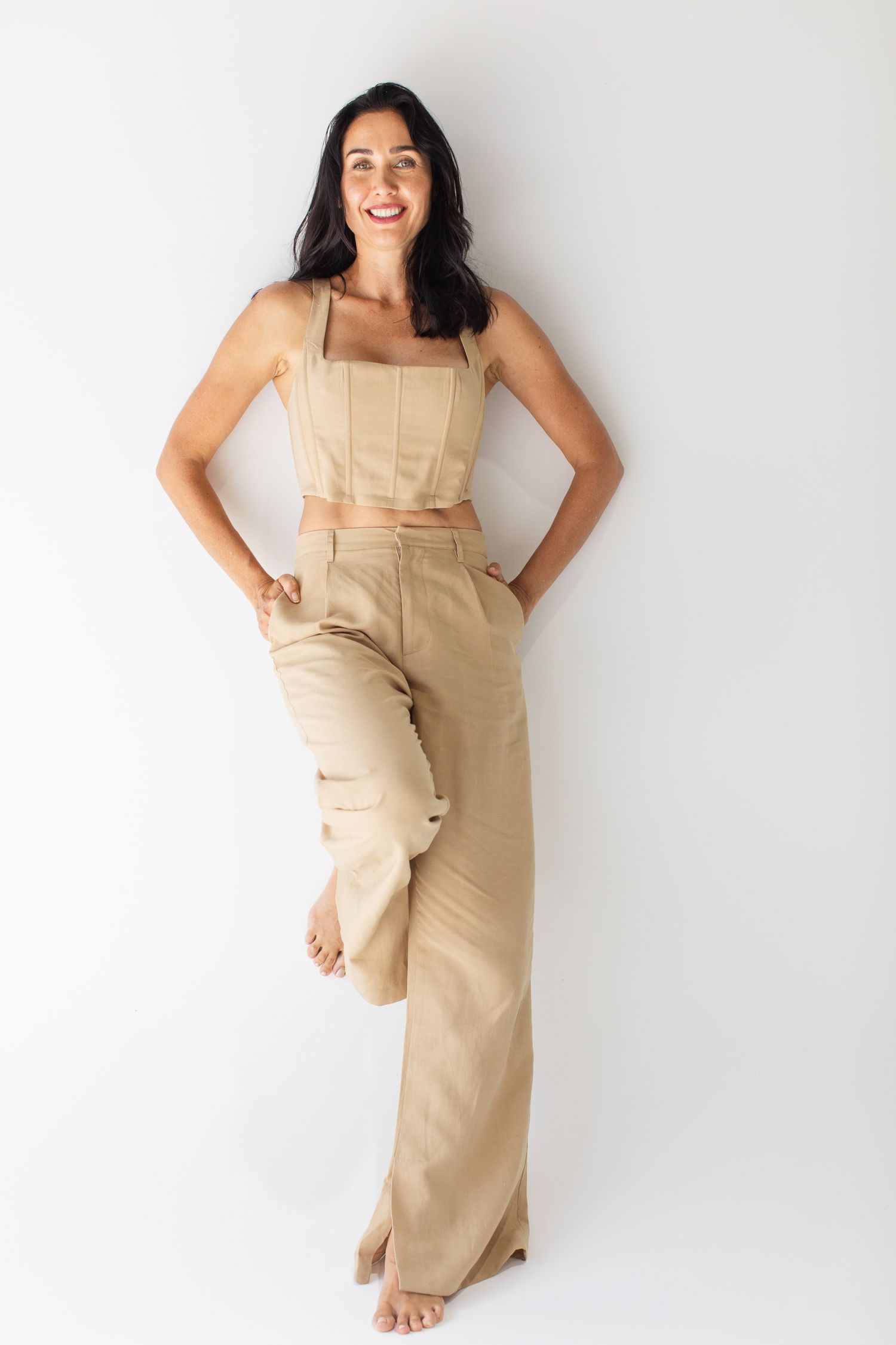 Model wearing beige linen overalls poses against white background in three different positions showing casual summer style.