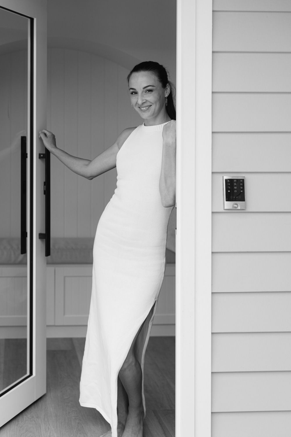 Minimalist black and white portraits at modern entrance with glass door.