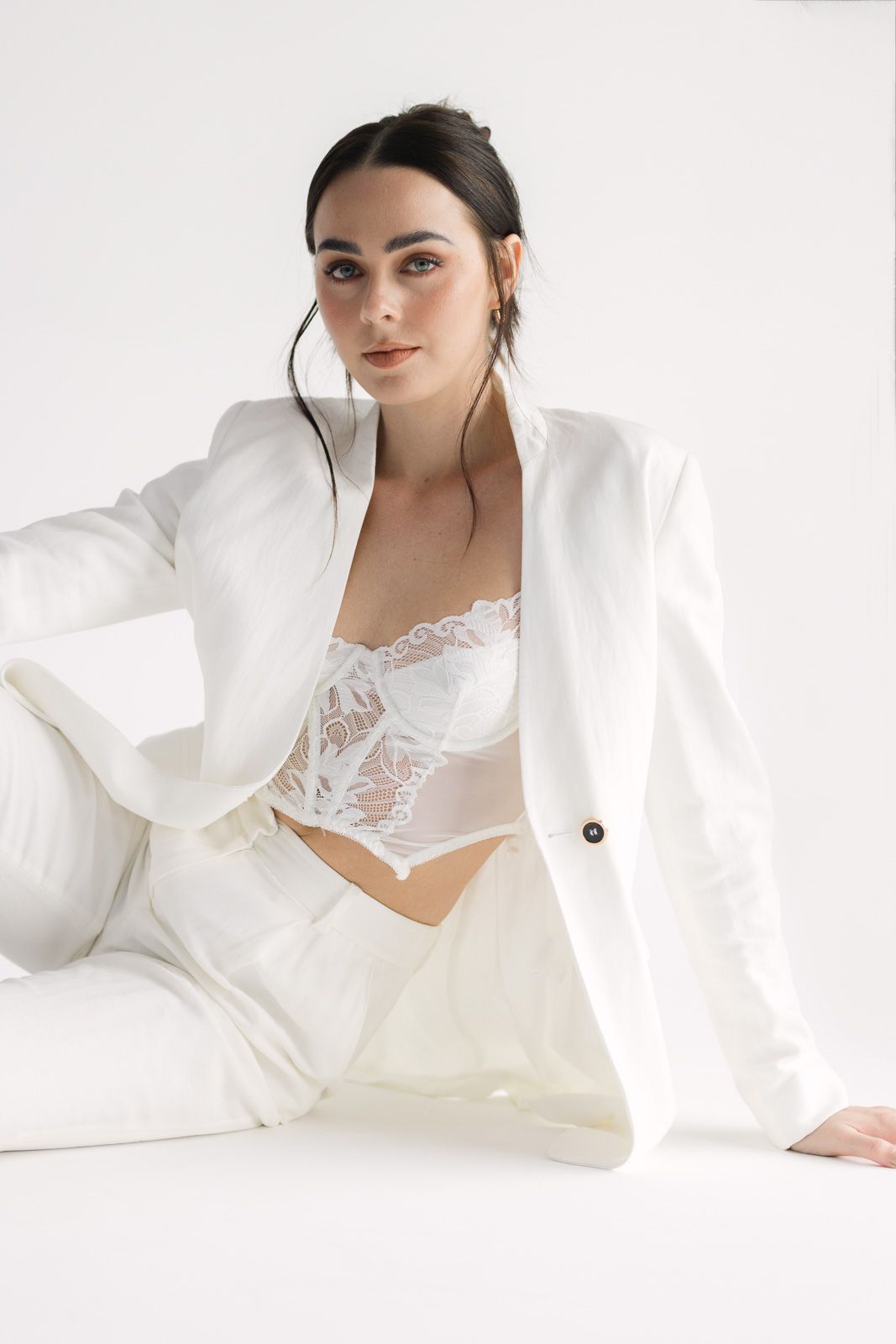 Bridal boudoir photo series featuring white lace lingerie and flowing fabric in an ethereal studio setting.