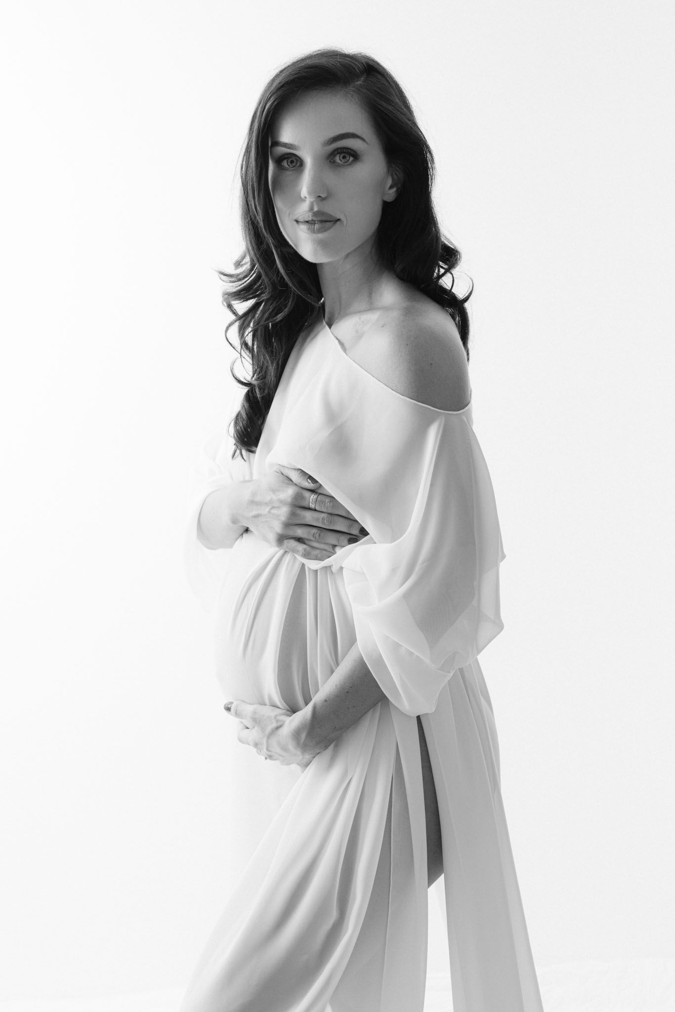 A series of black and white fashion portraits showing a model in a flowing white dress against a minimalist background.
