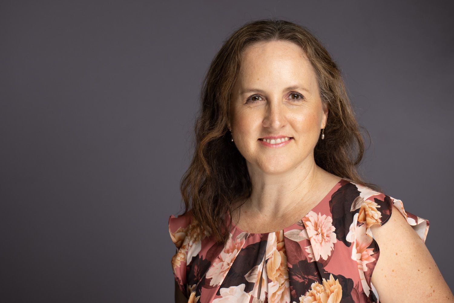 A professional headshot photo series showing different expressions and poses against a gray background.