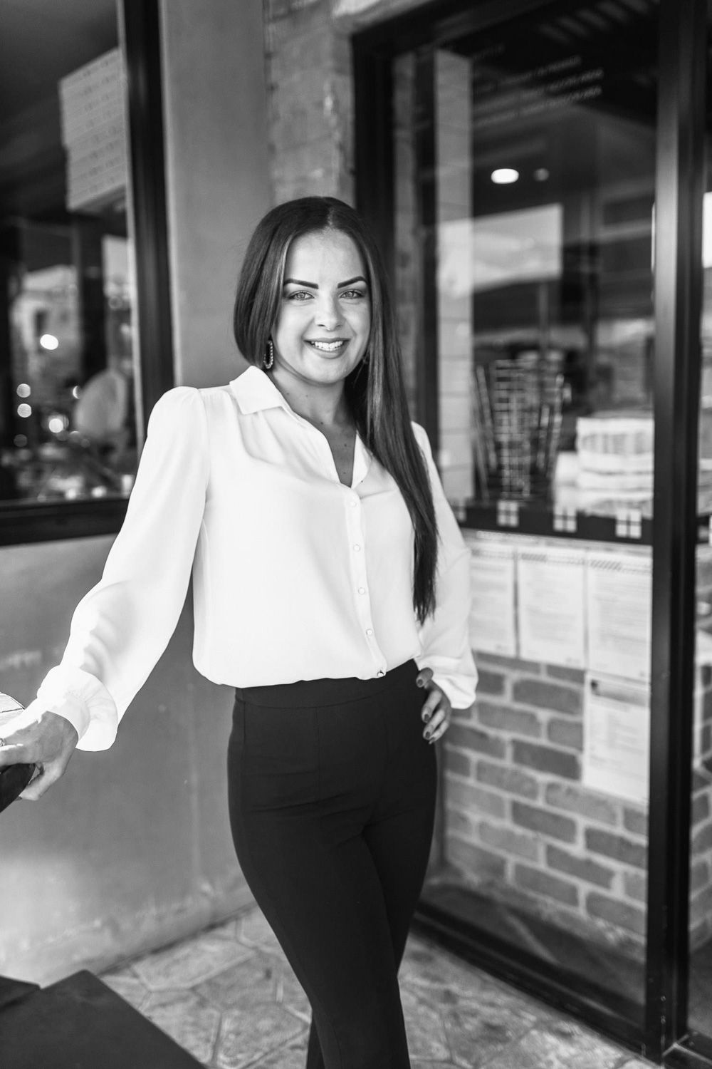 Stylish business attire featuring a crisp white blouse and black pants in an office environment.