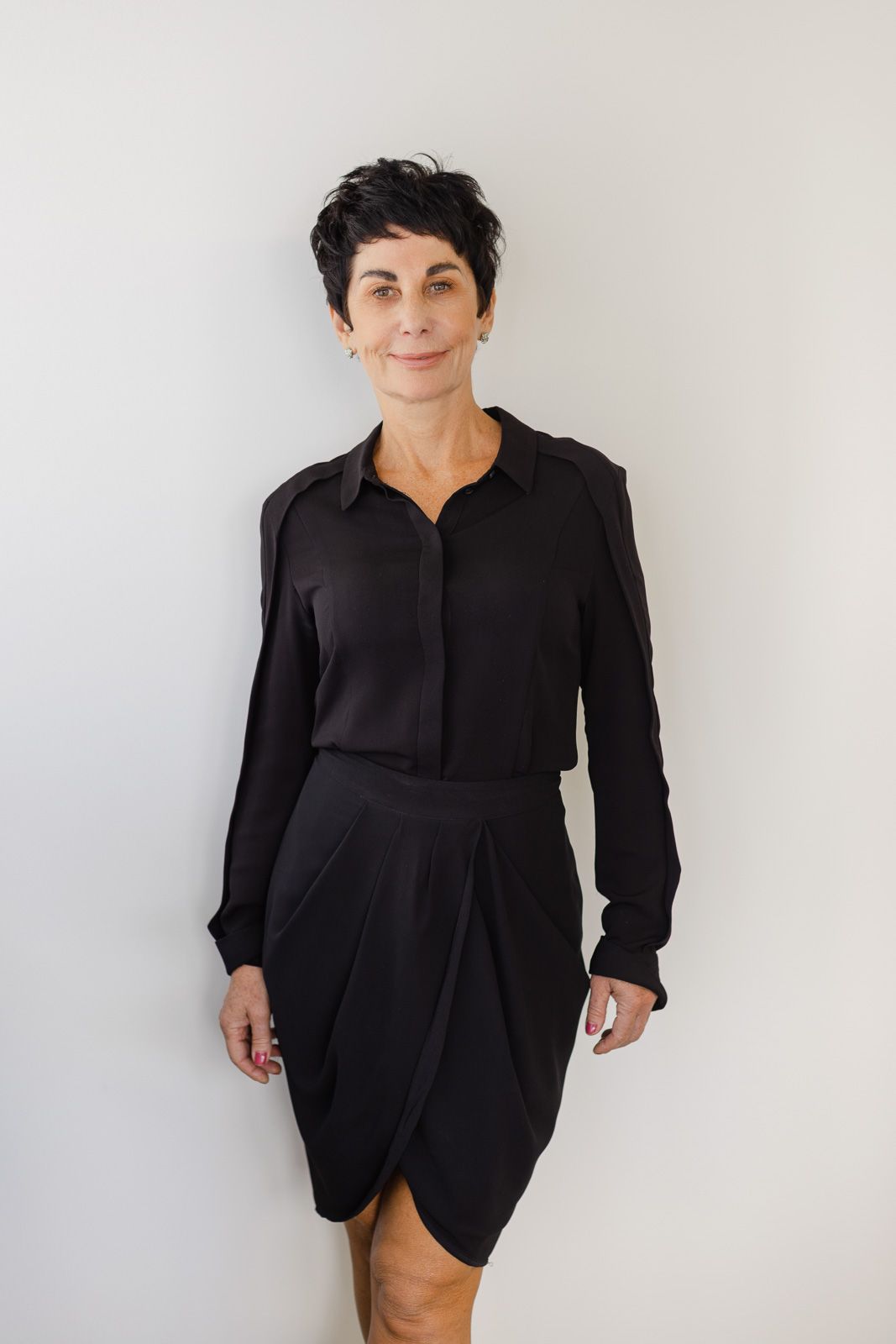 Person wearing a black button-up shirt dress poses against white background in four different angles.