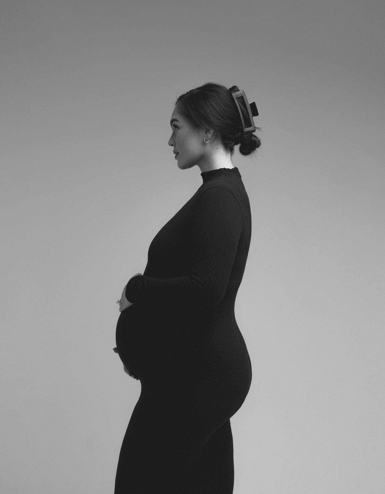 Minimalist black and white maternity silhouettes showing profile views.