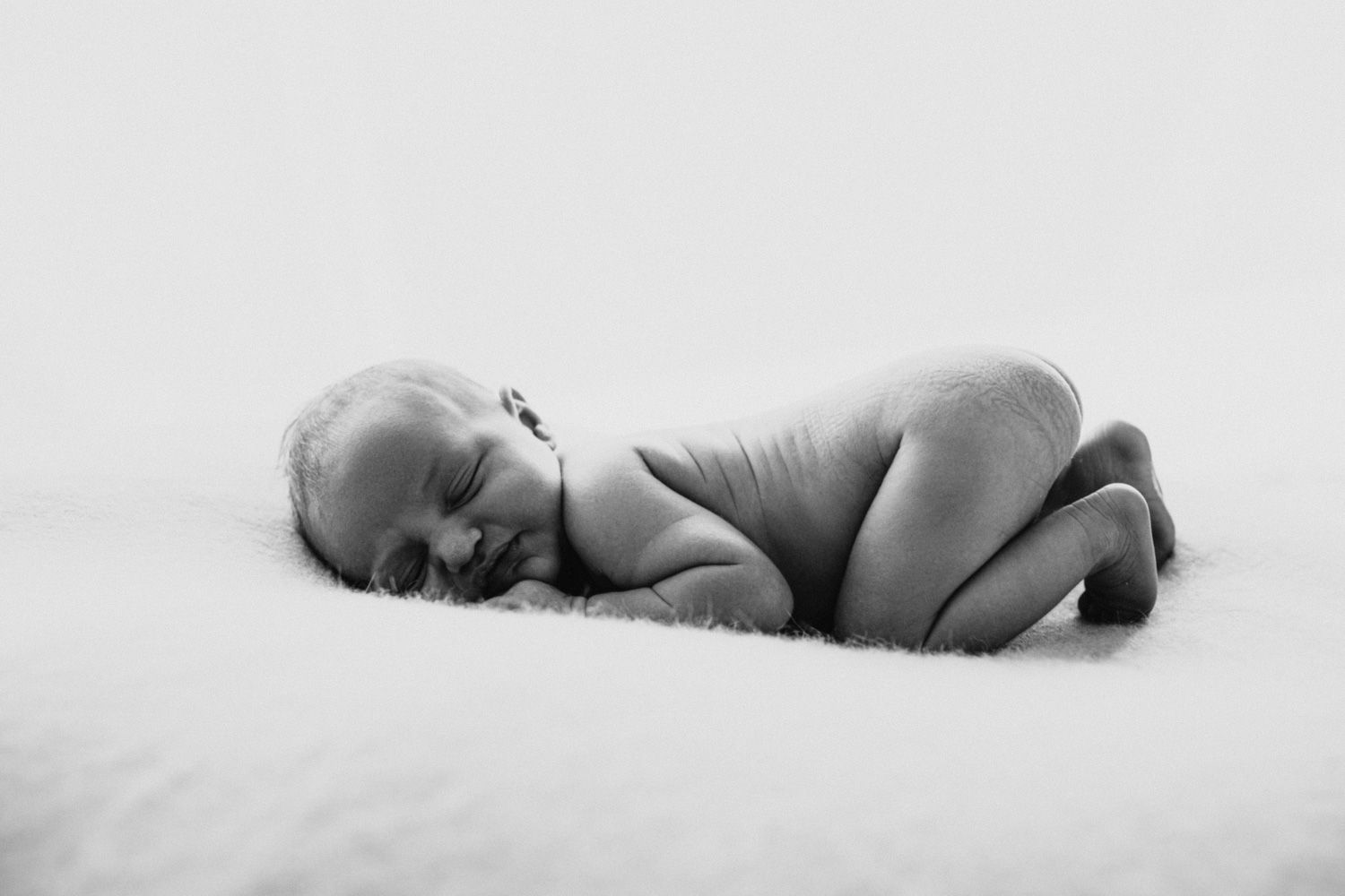Minimalist black and white portrait of a sleeping newborn baby.