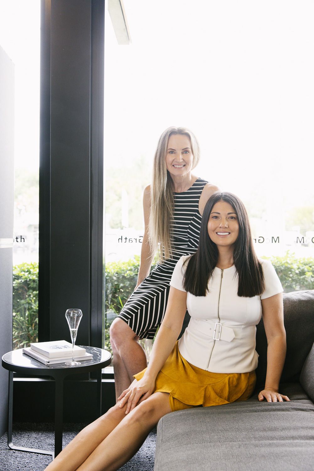 Casual lifestyle photos of women relaxing on grey couch in striped and white outfits.