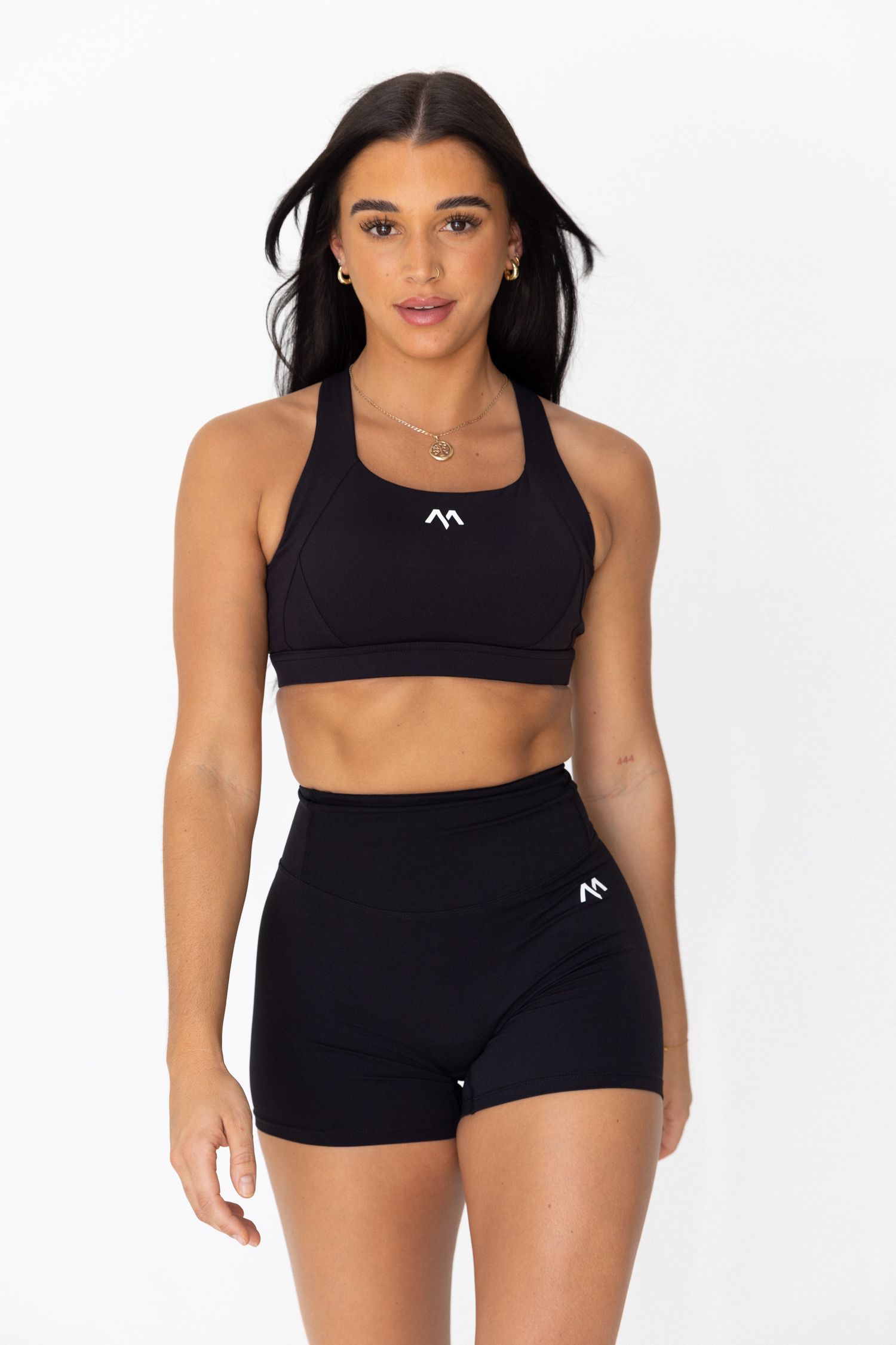 Black athletic wear collection featuring sports bras and shorts on a white background.
