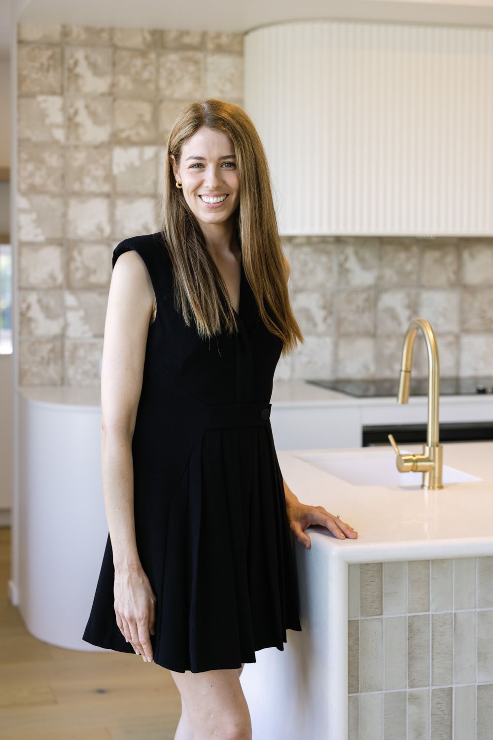 Interior design photo series showing a modern bathroom with white countertops and stone walls in warm neutral tones.