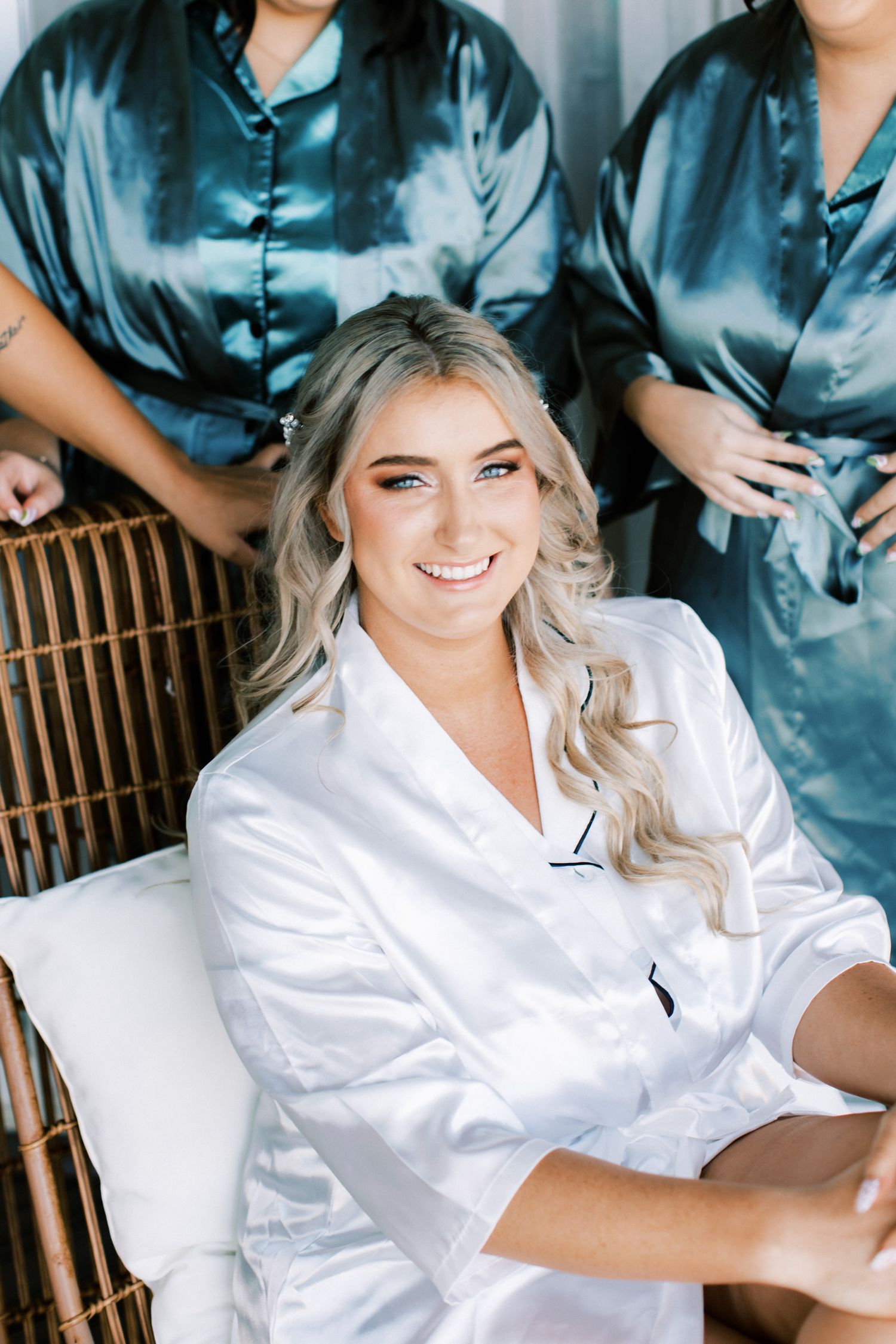 Getting ready photos showing person in white silk robe with styled blonde hair.