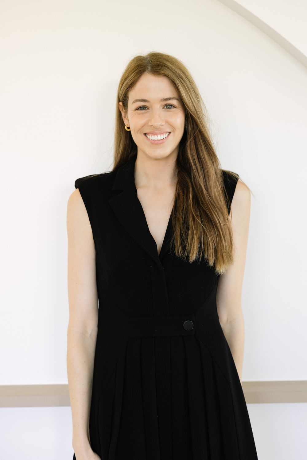 A series of four fashion portraits showing someone wearing a sleek black sleeveless top against a white background.